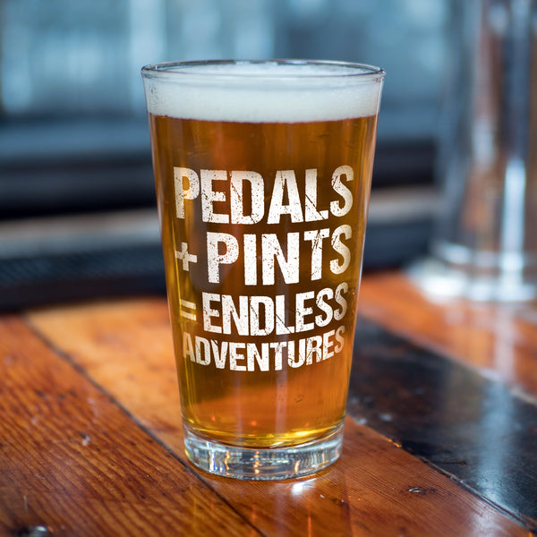 Introducing Crank Style's Cheers to Pedals + Pints = Endless Adventures Pint Glass, the ultimate companion for your beer-fueled escapades. This 16oz glass is more than just a vessel for your favorite brew—it symbolizes the thrill and camaraderie of hitting the trails.